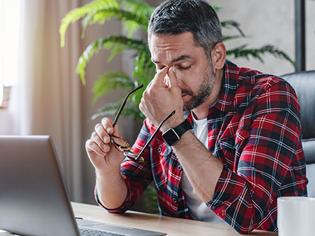 man with a migraine touching is face
