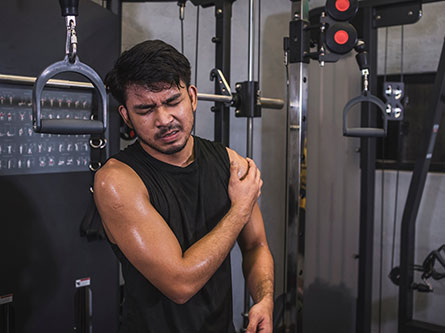man holding his shoulder with possible torn rotator cuff